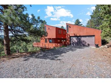 A distinctive modern two-story home with a two-car garage and rustic wood siding at 1278 Aspen Dr, Evergreen, CO 80439