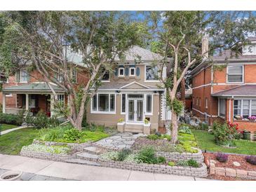 Charming two-story home with a beautifully landscaped front yard and mature trees at 1419 N Adams St, Denver, CO 80206
