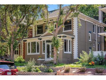Charming two-story home with brick and siding, a front porch, and mature trees in a landscaped yard at 1419 N Adams St, Denver, CO 80206