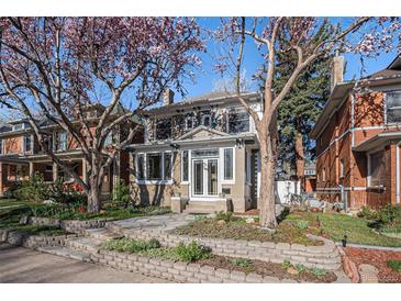 Charming two-story home featuring a lovely landscaped front yard with blooming trees and a stone walkway at 1419 N Adams St, Denver, CO 80206