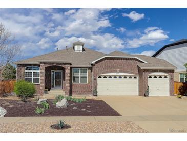 Charming brick home featuring an attached three-car garage, arched entryway, and landscaped front yard at 24621 E Berry Pl, Aurora, CO 80016