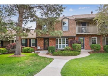Charming townhome featuring a brick facade, well-manicured landscaping, and inviting walkway at 8981 E Amherst Dr # E, Denver, CO 80231