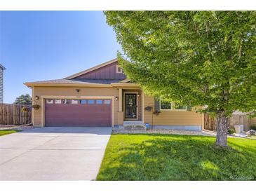 Charming single-Gathering home featuring a well-manicured lawn, mature tree, and a two-car garage with an inviting entry at 5280 Raritan Way, Denver, CO 80221