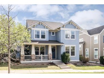 Charming two-story home featuring blue siding, white trim, a welcoming front porch, and well-manicured landscaping at 7382 E 8Th Pl, Denver, CO 80230