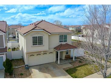 Inviting two-story home with a tile roof, covered front porch and attached two car garage at 5559 Gibraltar St, Denver, CO 80249