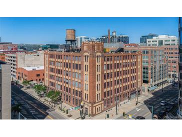 Attractive exterior view of a historic building with brick facade and water tower in a bustling urban environment at 1863 Wazee St # 4E, Denver, CO 80202