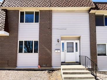 Exterior view of townhome featuring brick and vinyl siding, front door, and landscaping at 630 S Youngfield Ct, Lakewood, CO 80228