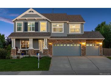 Charming two-story home with a stone facade, manicured lawn, and a three-car garage at 7083 Winthrop Cir, Castle Rock, CO 80104