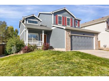 Charming two-story home with red shutters, a gray garage, and a well-manicured front yard at 9885 Thornbury Way, Highlands Ranch, CO 80129