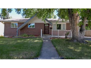 Charming brick home with a well-maintained lawn and inviting walkway at 8438 Ames St, Arvada, CO 80003