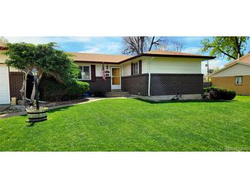 Charming single-story home with a well-manicured lawn, brick accents, and an inviting entrance at 9584 W Kentucky Ave, Lakewood, CO 80226