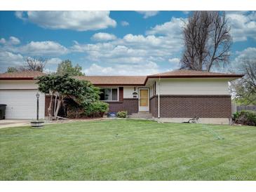 Ranch-style home with a well-maintained front yard, brick accents, and mature landscaping at 9584 W Kentucky Ave, Lakewood, CO 80226