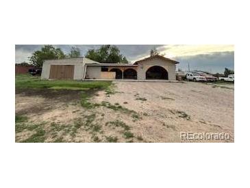 Ranch-style home with a unique arched carport and a spacious gravel driveway at 7115 Harold St # 2, Fort Lupton, CO 80621