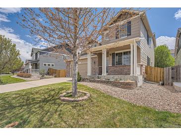 Charming two-story home with a well-maintained lawn, front porch, and welcoming curb appeal at 4037 S Odessa Cir, Aurora, CO 80013
