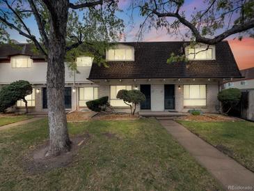 Charming townhome features a brick facade, trimmed shrubs, and a manicured lawn, creating inviting curb appeal at 1103 S Monaco Pkwy, Denver, CO 80224