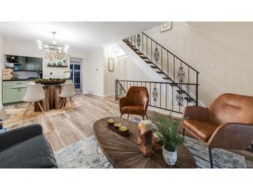 Open concept living area features modern design, hardwood floors and stairway with rod iron balusters at 1103 S Monaco Pkwy, Denver, CO 80224
