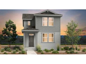 Charming two-story home featuring gray siding, complemented by lush landscaping at 2078 Wagon Wheel Aly, Brighton, CO 80601