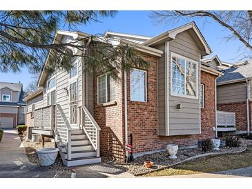 Charming home featuring brick and siding, plus a welcoming staircase to the entrance at 7915 Flower St # D, Arvada, CO 80005