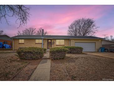 Charming single-story brick home featuring mature landscaping and an attached garage at 12434 E Alaska Ave, Aurora, CO 80012