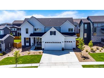 Charming two-story home boasts a manicured lawn, three-car garage and modern architectural details at 14441 Shasta Daisy Ln, Parker, CO 80134