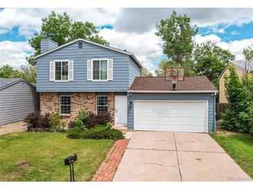 Charming two-story home with blue siding, brick accents, attached garage, and well-maintained landscaping at 3916 S Telluride Ct, Aurora, CO 80013