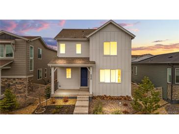Charming two-story home featuring modern design, landscaped yard, and a welcoming front porch with a blue front door at 8028 Williams Fork Ave, Littleton, CO 80125
