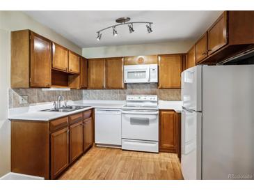 Traditional kitchen featuring wood cabinets, white appliances, and neutral countertops at 745 S Alton Way # 9B, Denver, CO 80247