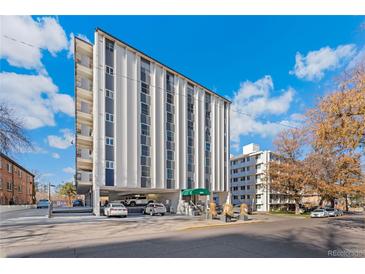 Modern condo building featuring a concrete parking area and a blue sky backdrop at 1265 Race St # 203, Denver, CO 80206