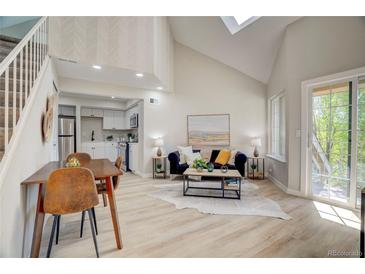 Bright living room featuring vaulted ceilings, skylights, and an open floor plan to the kitchen at 5950 Gunbarrel Ave # F, Boulder, CO 80301