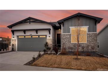 Charming single-Gathering home featuring a two-car garage and tasteful stone and siding accents at 5681 Water Avens Dr, Castle Rock, CO 80104