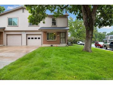 Traditional home featuring a well-manicured lawn and an attached two-car garage in a tranquil neighborhood at 1765 S Kline Way, Lakewood, CO 80232