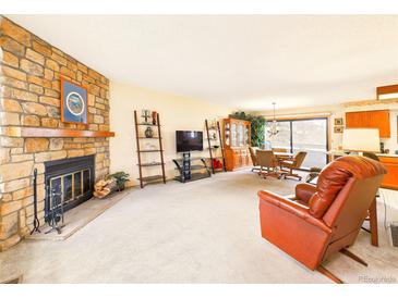 Inviting living room featuring a stone fireplace, plush carpeting, and a comfortable layout for relaxation at 8777 W Cornell Ave # 2, Lakewood, CO 80227