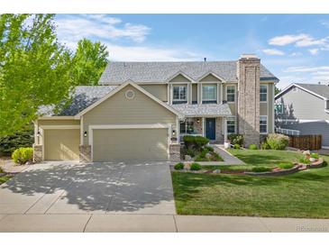 Inviting two-story home boasts a manicured lawn, three-car garage, and charming stone accents, perfect for suburban living at 7837 Aravon Ct, Lone Tree, CO 80124