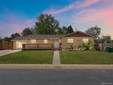 Charming ranch-style home with a well-manicured lawn and inviting wooden deck in a quiet neighborhood at 1195 S Kendall St, Lakewood, CO 80232