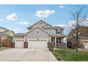 Charming two-story home with a three car garage, inviting porch, and well-maintained landscaping at 5362 E 140Th Pl, Thornton, CO 80602