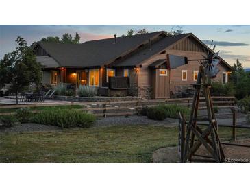 Stunning exterior of a wood home with a beautiful, landscaped yard and windmill feature at 7130 Independence St, Arvada, CO 80004