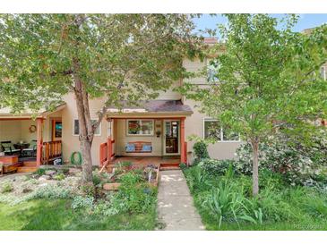 Charming home exterior with a welcoming porch swing, red wood trim, lush garden, and mature trees enhancing curb appeal at 1460 Quince Ave # 102, Boulder, CO 80304