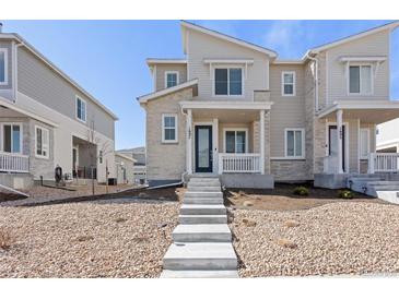 Charming townhouse featuring stone accents, a covered front porch, and inviting curb appeal at 1697 S Andes Way, Aurora, CO 80017