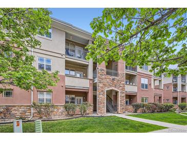 Beautiful condo building with stone accents, balconies, and lush landscaping at 8083 W 51St Pl # 203, Arvada, CO 80002