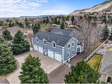 Stunning home featuring a spacious four-car garage, complemented by a beautifully landscaped yard and scenic mountain views at 5753 Secrest Ct, Golden, CO 80403