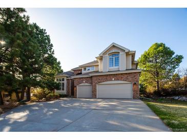 Charming two-story brick home featuring an attached two-car garage and a well-manicured front yard at 924 Glen Oaks Ave, Castle Pines, CO 80108