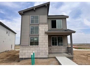 Modern two-story home showcasing a blend of gray siding and stone accents, enhancing its curb appeal at 24251 E 54Th Pl, Aurora, CO 80019
