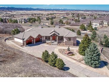 Expansive luxury home boasts meticulous landscaping and a circular driveway with a water feature at 1252 Rosewind Cir, Castle Rock, CO 80104