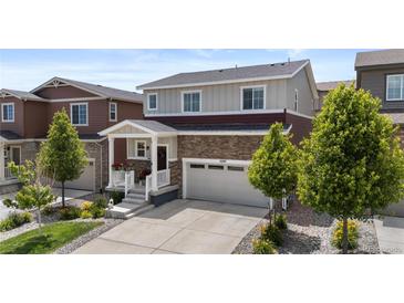 Charming two-story home with brick accents, a well-manicured lawn, and an attached two-car garage at 5297 Blue Lunar Ln, Castle Rock, CO 80104