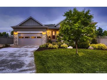 Charming single Gathering home featuring manicured lawn, stone accents, and an attached garage at 6652 W Asbury Pl, Lakewood, CO 80227