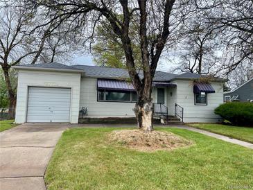 Charming single-story home featuring a garage, well-kept lawn and decorative awnings at 4549 S Acoma S St, Englewood, CO 80110