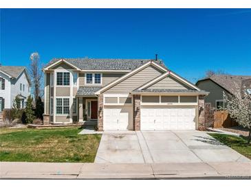 Charming two-story home with a well-maintained lawn, a three car garage and classic architectural details at 18995 E Bellisario Creek Pl, Parker, CO 80134