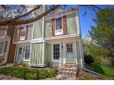 Charming townhome featuring a light green exterior, red shutters and well-maintained landscaping at 10735 W Dartmouth Ave, Lakewood, CO 80227