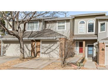 Charming townhouse featuring a brick facade, attached garages, and a well-maintained walkway to the front doors at 12089 W Chenango Dr, Morrison, CO 80465