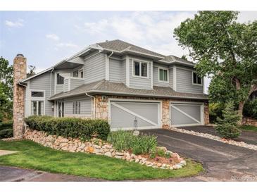 Charming home features a stone accents, two-car garage, and manicured landscaping at 185 Players Club Dr, Castle Rock, CO 80104